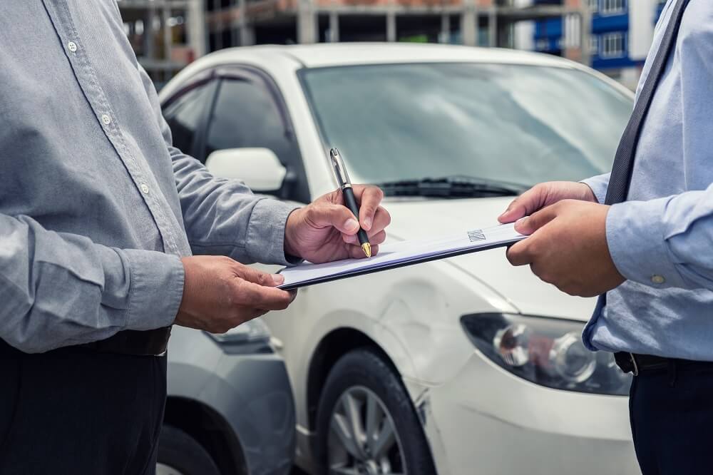 Insurance agent checking car damages from car accident.