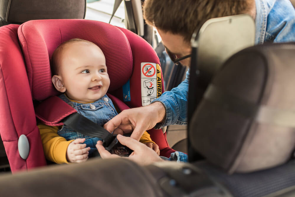 Baby sitting on a carseat for safety.