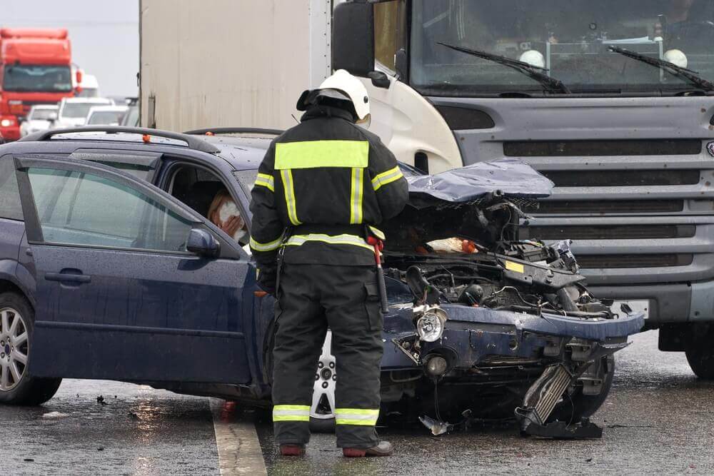 Sedan car and truck in left-turn accident along the highway.